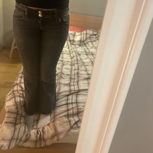 Svarta bootcut jeans - Snygga svarta bootcut jeans med låg midja och dubbla knappar fram. Perfekta för en avslappnad stil. De har fickor både fram och bak. Storlek 146, jag på bilden är 162. 