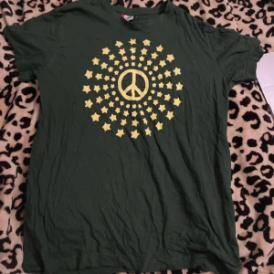 Grön t-shirt med peace märke - Snygg grön t-shirt från Clique, bra skick, använd köp nu