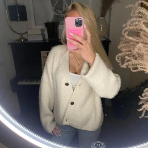 Vit kofta med knappar - Mysig vit kofta med knappar framtill. Den är nopprig men den är jätte snygg