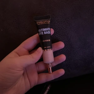 Ultimate Eye Base från Revolution - Säljer en Ultimate Eye Base från Revolution i färgen Medium. Perfekt för att skapa en jämn bas för ögonskugga. Tuben innehåller 15 ml och har en praktisk applikator för enkel användning.