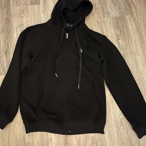 Svart polo ralph lauren zip hoodie - Säljer en ralph lauren hoodie i bra skick. Säljer för att den blivit för liten på mig. Storlek L men passar även M                       