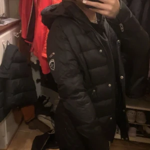 Svart dunjacka från Rockandblue - Säljer en snygg svart dunjacka från Rockandblue med huva och dragkedja. Jackan har långa ärmar och flera praktiska fickor med dragkedjor. Perfekt för kyliga dagar. Inga skador eller slitningar, svårt päls luva finns även också. Pris kan diskuteras och fler bilder kan skickas privat!!💕