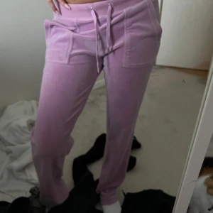 Juicy byxor - Säljer ett par rosa mjukisbyxor från Juicy Couture i storlek XS. Jättefina fortfarande det ända är en av metall sakerna från snörerna saknas, syns i sista bilden