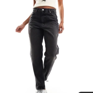 Svarta jeansbyxor - Snygga svarta jeansbyxor med hög midja och straight passform. Perfekta för en stilren look. De har klassiska fem fickor och knappgylf.