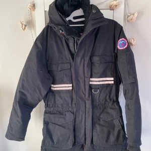 Svart vinterjacka från First Slope - Säljer en svart vinterjacka från First Slope med huva och flera dragkedja och fickor .jackan är otroligt varm . Storlek i smal men den är jätte stor smal , som en medium . Perfekt för kalla dagar.kan möta er i Stockholm utanför 