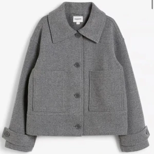 Grå ulljacka från KappAhl - Säljer en snygg grå ulljacka från KappAhl. Nästan inte använd och den är i nytt skick . Den har en klassisk krage och stora knappar framtill. Jackan är i normal passform och har långa ärmar med knappar vid ärmsluten. Perfekt för höst och vår! Pris går att diskutera!❤️