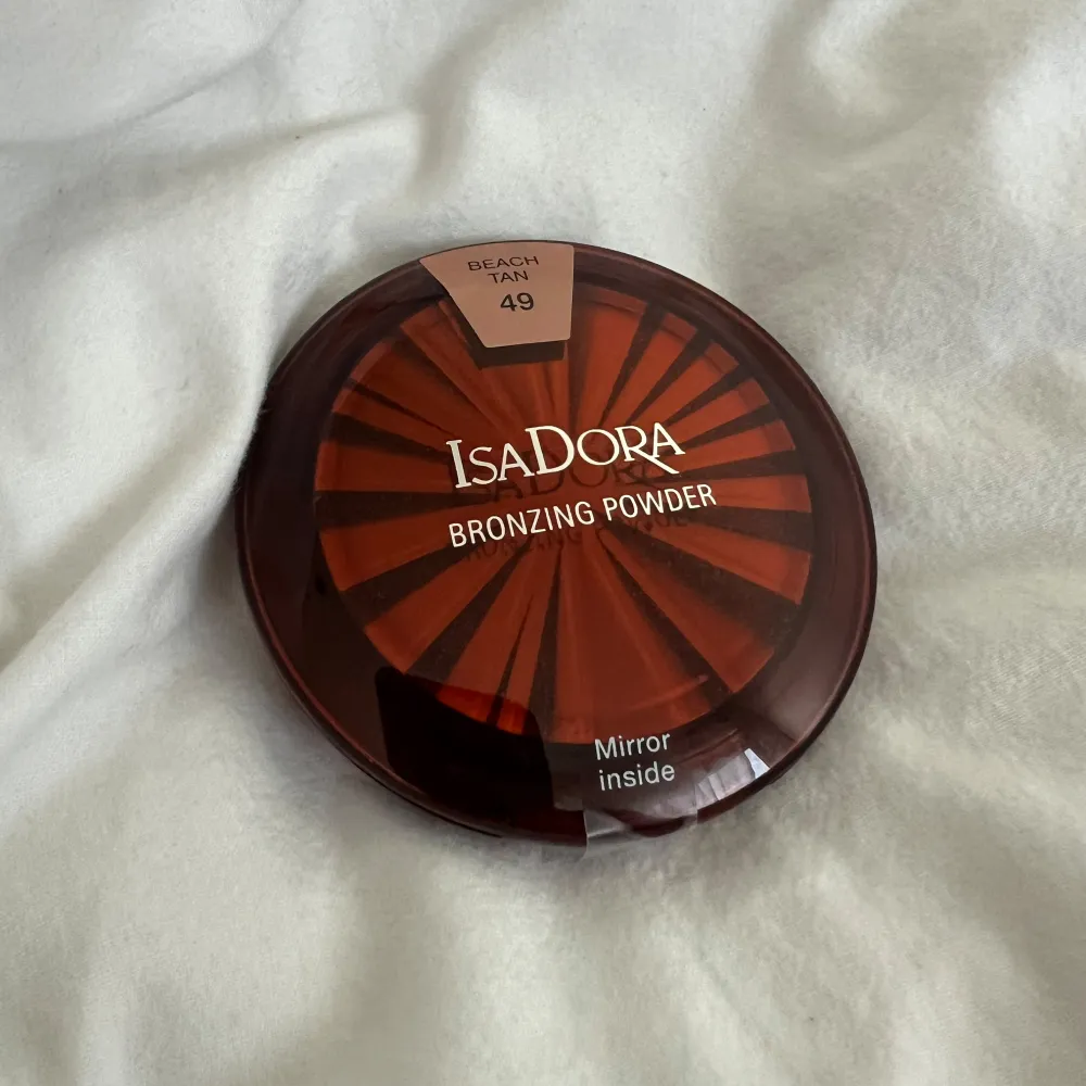 Säljer ett Isadora Bronzing Powder i nyansen Beach Tan 49. Perfekt för att ge ansiktet en solkysst look. Kompakt förpackning med spegel inuti, vilket gör den smidig att ha med sig. Perfekt för att fräscha upp sminket under dagen!. Skönhet.