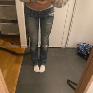 Blå jeans med slitningar - Säljer ett par snygga blå jeans i mycket bra skick. De är lågmidjade med slitningar på knäna för en cool look. Perfekta för modemedvetna tjejor😽😽 Innerbenslängd 78 ish och midjemått 38 ish rakt över, jag är 1,69cm och byxorna passar mig i längden 