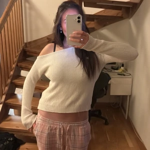 offshoulder tröja - Säljer en superfin vit ribbad tröja med offshoulder-design. Perfekt för en avslappnad stil, den har långa ärmar och en skön passform. Passar både till vardags och lite festligare tillfällen. 🖤