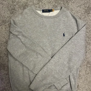 Grå sweatshirt från Polo Ralph Lauren - Säljer en stilren grå sweatshirt från Polo Ralph Lauren i storlek S. Tröjan är i mycket bra skick och är perfekt under alla årstider 