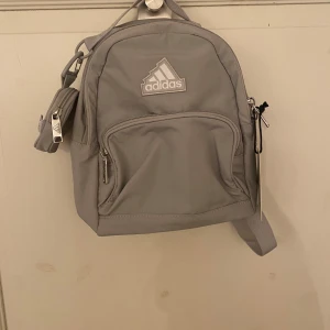 Grå ryggsäck Adidas - En praktisk och söt ryggsäck från Adidas! Aldrig använd med lappen kvar💕