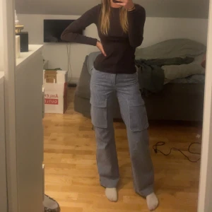 Randiga cargobyxor från Pull&Bear - Säljer ett par snygga randiga cargobyxor från Pull&Bear i storlek EUR 32. Byxorna är blå och vita med en loose passform och hög midja De är i mycket bra skick och passar perfekt för både vår och höst.