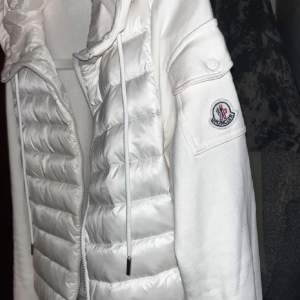 Säljer en snygg vit jacka från Moncler. Den har en quiltad framsida med dragkedja och en huva med snörning. Perfekt för kyliga dagar och ger en stilren look. Moncler-loggan syns på ärmen. Passar både till vardags och lite finare tillfällen, jackan används inte pg av att jag inte passar inte i den och behöver pengar för mer information kontakta mig, förresten passa på den kmr säkert bli såld snabbt😉✅