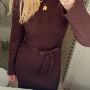 Stickad klänning  - Söt brun/röd stickad klänning från VILA. Storlek S och har band i midjan som går att knyta. Aldrig använd, nyskick.  Bara att skriva för fler bilder 💞💞