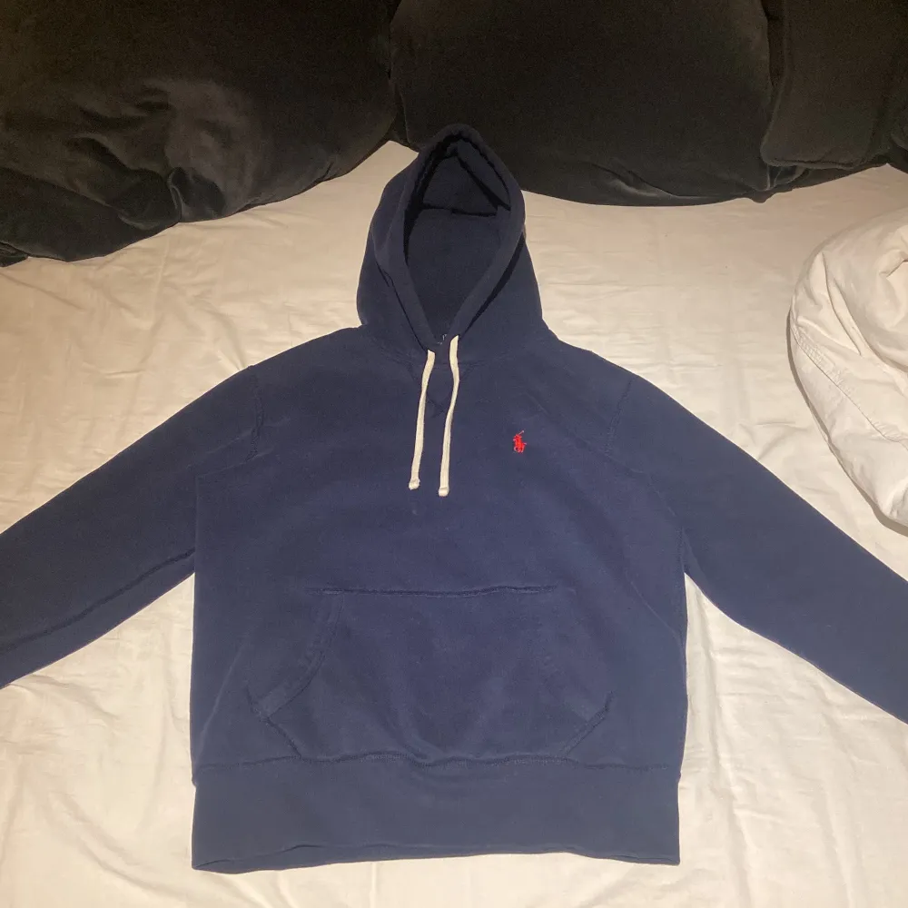 Säljer en snygg blå hoodie från Ralph Lauren i nyskick. Den har en klassisk design med en liten röd logga på bröstet och vita snören i huvan. Perfekt för en avslappnad stil och passar till de flesta tillfällen. Superbekväm och stilren! Nypris ligger på 2000kr. Hoodies.