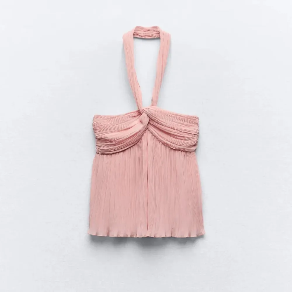 Säljer en superfin rosa halterneck topp med plisserade detaljer. Perfekt för sommarens fester eller en dag på stan. Toppen har en elegant drapering framtill och är i ett lätt och luftigt material.. Yläosat.