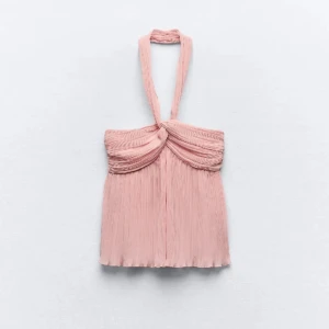 Rosa halterneck topp - Säljer en superfin rosa halterneck topp med plisserade detaljer. Perfekt för sommarens fester eller en dag på stan. Toppen har en elegant drapering framtill och är i ett lätt och luftigt material.
