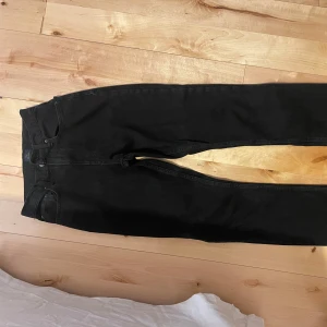 Svarta högmidjade jeans  - Säljer ett par svarta jeans från NLY Jeans i bra skick. De har en klassisk design med normal passform och är perfekta för både vardag och fest. Jeansen är högmidjade och raka i benen. Obs det står inte vilken storlek det är i jeansen men skulle säga Xxs-xs. Säljer ett par likadana fast med slits nertill🤗