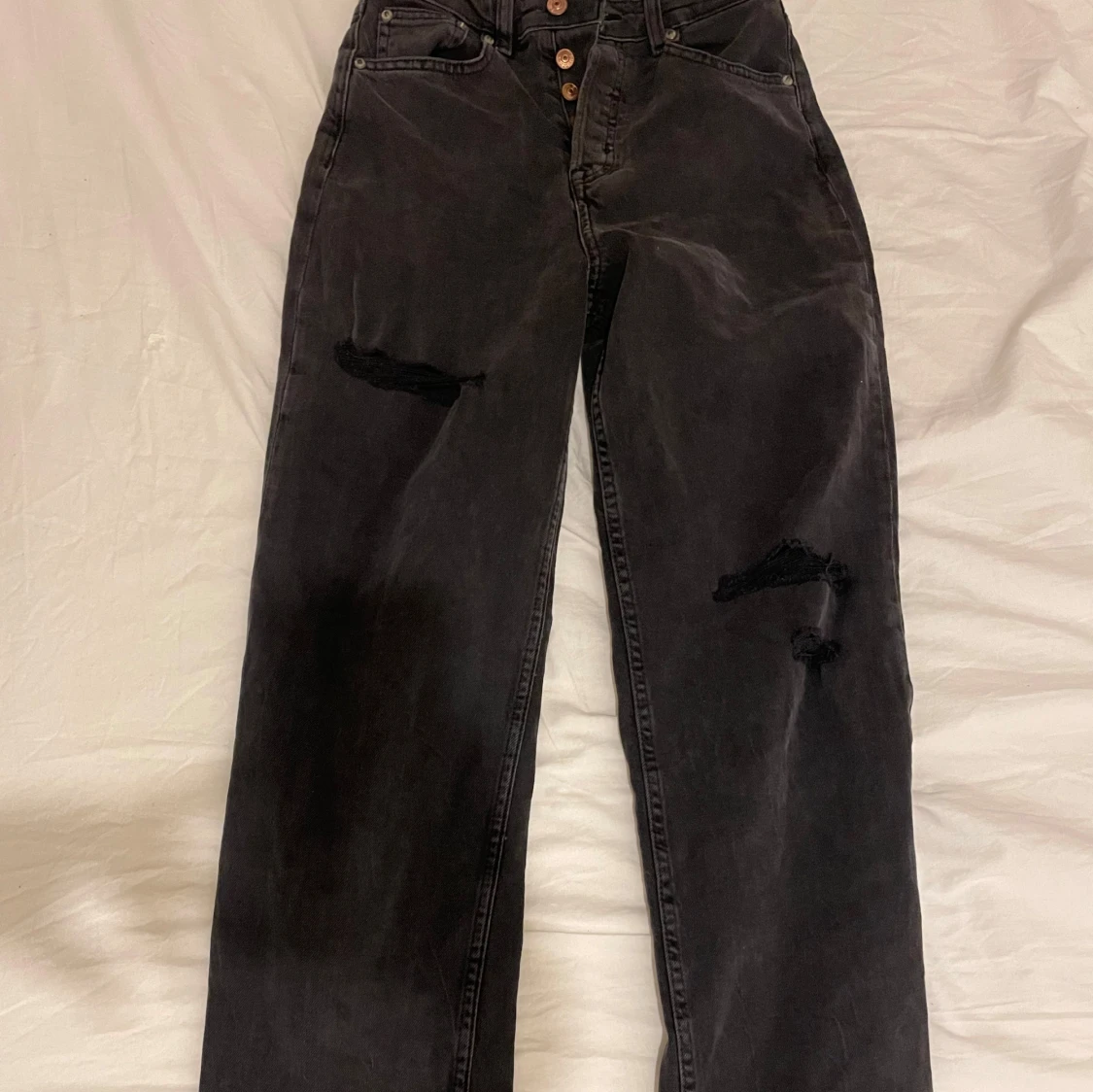 Svarta jeans med slitningar