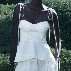 Vit ärmlös topp - Säljer en söt vit ärmlös topp med tunna axelband. Bra skick, finns en liten fläck på tröjan men går att fixa 