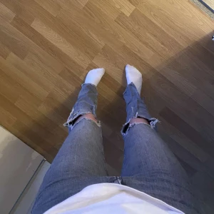 Grå jeans bootcut jeans ZARA - Säljer ett par grå bootcut jeans från Zara i storlek 36. De finns fickor fram, bak och hål på knäna. Skulle säga att de är i bra skick och har inga hål eller så utom att det finns små blekningsfläckar på höger bakben som syns på sista bilden. 💗
