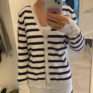 Randig kofta från Zara - Säljer en superfin randig kofta från Zara i storlek XL. Jag är själv Xs/S och passar mig perfekt eftersom själva materialet är tight. Den är vit med mörkblå ränder och har knappar framtill. Perfekt för både vår och höst, och funkar lika bra till vardags som till lite finare tillfällen. Koftan är i bra skick och väldigt bekväm att ha på sig. 