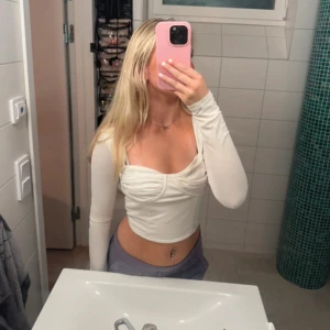 Vit långärmad topp från Bik Bok - Säljer en snygg vit långärmad topp från Bik Bok i storlek S. Toppen har en tight passform med en korsettliknande design och rynkade detaljer vid bysten. Perfekt för både vardag och fest! 💫