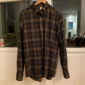 Rutig skjorta från Stenströms - Säljer en snygg rutig skjorta från Stenströms i storlek large. Skjortan är i slim fit och tillverkad av 100% bomull, vilket gör den både bekväm och stilren. Perfekt för höst och vinter med sina långa ärmar och klassiska knappar. Passar både till vardags och festliga tillfällen!