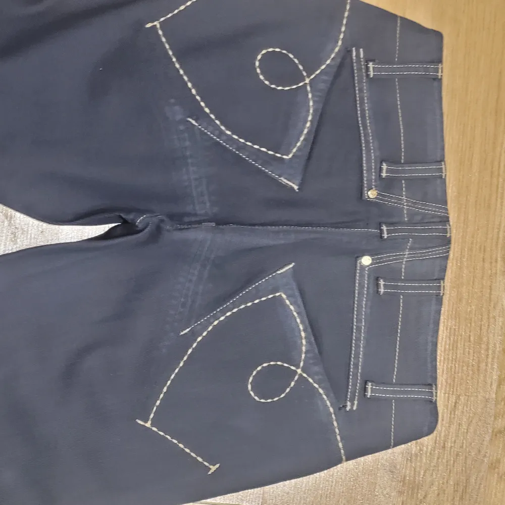 Säljer ett par snygga mörkblå jeans från Girbaud i storlek 26. De har en klassisk femficksdesign med coola sömdetaljer på bakfickorna. Jeansen är i nytt skick med etikett kvar. Perfekta för både vardag och fest!. Jeans & Byxor.