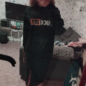 Svart hoodie med tryck - Säljer en svart hoodie med ett coolt tryck i vitt och orange. Perfekt för en avslappnad stil och passar bra till jeans eller leggings. Den har en normal passform och är superbekväm för vardagsbruk.