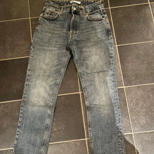 Blå jeans från Zara - Säljer ett par blå jeans från Zara i bra skick. De har en klassisk straight fit och är tillverkade i ett slitstarkt denimtyg.
