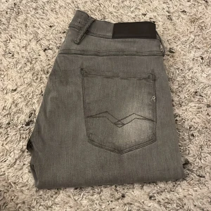 Grå jeans från Replay - Säljer ett par snygga grå jeans från Replay i bra skick. Har använt dem i typ ett halvt år, köpt 1499 kr säljer nu för 799 kr. Pris går att diskutera. Byxorna är förkortade så dem är nog i långd L30 och W34. Skriv vid intresse! 