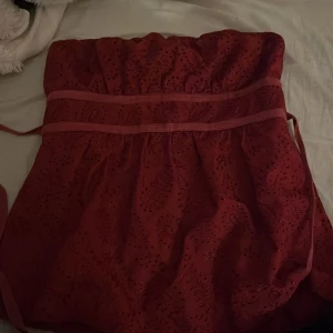 Röd topp från Charlotte Russe - Snygg röd klänning från Charlotte Russe med broderade detaljer och knytband i midjan. . Axelbandslös design använd en gång🩷.