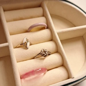 Ringar - Fyra olika ringar, ring 1 är en rosa ring som ör guldfärgad inuti den ör från H&M(aldrig använd). Ring 2 är en guldfärgad ring med olika faktorer diamanter i, den är justerbar. Ring 3 är en silverfärgad ring som är en blommaktig snurr. Ring 4 en rosa/genomskinlig från H&M(aldrig använd). Alla ringar för 90kr annars 25 kr st