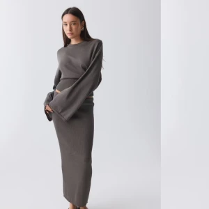 Grå stickad kjol från Gina Tricot - Snygg grå stickad kjol från Gina Tricot i en tight passform. Kjolen är lång och perfekt samt glittrig vilket passar perfekt för fest eller om man vill spicya upp sin vardag! Den har en enkel design som gör den lätt att matcha med olika toppar. Storlek S! 