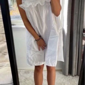 Vit axelbandslös klänning från H&M - Säljer en söt vit klänning från H&M med volangdetaljer upptill. Perfekt för varma sommardagar eller studenten. Klänningen har en luftig passform och är gjord i ett lätt material. Den är i storlek S.🌸 De första två bilderna är lånade!💕