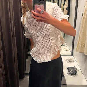 Vit spetsblus från Zara - Säljer en vit spetsblus från Zara med volangdetaljer. Använd fåtal gånger!💕