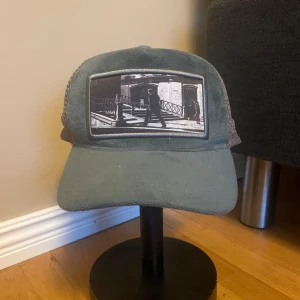 Emilio Pendenza keps - Grön Emilio Pendenza keps. Kepsen har ett nätmaterial på sidorna och justerbar rem baktill. Pris kan diskuteras.