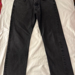 Svarta jeansbyxor från Weekday - Snygga svarta jeansbyxor från Weekday med klassisk design. De har en rak passform och är tillverkade i ett slitstarkt material. Perfekta för en stilren look.