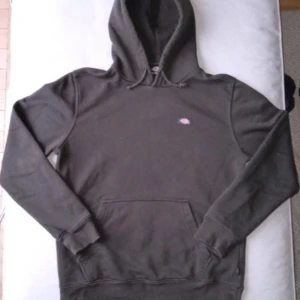 Mörkgrå hoodie från Dickies - Säljer en mörkgrå hoodie från Dickies med klassisk design och känguruficka. Perfekt för en avslappnad stil. Hoodien har en liten logga på bröstet och är tillverkad i bomull och polyester för extra komfort.