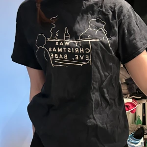 Svart t-shirt med tryck - Säljer min T-shirt med ett tryck från låten ”Fairytale of New York” av bandet The Pogues och Kirsty MacColl.