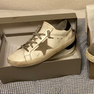 Golden Goose - Säljer ett par vita sneakers från Golden Goose Skorna har en klassisk design med slitna detaljer för en vintage-look. Slitet skick därav priset. Kan gå ner i pris vid snabb affär🤝Hör av er vi funderingar🙌🏽 Mvh- Gustav✅