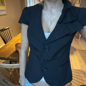 Kavaj topp - Jätte fin kavaj topp med detaljer, i jätte fint skick då den nästan aldrig använd. På bilden är knappen i mitten inte kläppt men den har alla knappar. Skriv för fler bilder!!