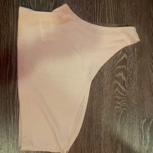 Beige ribbad bikiniunderdel från Lishly - Snygg beige bikiniunderdel från Lishly i ribbat material. Perfekt för sommarens stranddagar. Tillverkad i 95% polyester och 5% elastan för en bekväm passform. om ni vill köpa denna sommar topp så får ni stå för frakten.