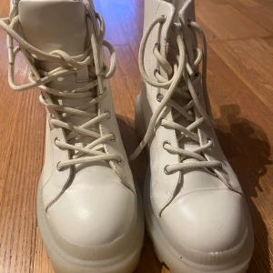 Vita boots från H&M Divided - Snygga vita boots från H&M Divided med snörning och en robust sula. Perfekta för en stilren look. Har även en klassisk design som passar till många outfits.