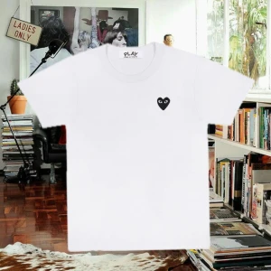 Vit t-shirt från Comme des Garçons - Säljer en stilren vit t-shirt från Comme des Garçons med det ikoniska svarta hjärtat broderat på bröstet. T-shirten har en klassisk passform. Köpt för 1000kr på nk 