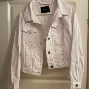 Vit jeansjacka  - Supersnygg vit jeansjacka från Rut & Circle. Har lite slitningar och aningen croppad design vilket skapar en väldigt snygg look. Köpt för flera år sedan på NAKD för 499kr. Nyskick då den är helt oanvänd och även har skydd kvar kring knappar samt prislapp. Storlek 36. 🌸