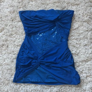 Blå tubtopp - Snygg blå tubtopp med paljetter och knyt-detaljer framtill från Jane Norman ✨Perfekt för en utekväll 💙Använd men inga defekter! Skriv om du har några funderingar ☺️