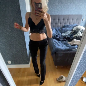 Svart spetslinne - Säljer ett svart spetslinne med smala axelband och vacker spetsdetalj. Perfekt för en stilren och elegant look. Är en bralette och hade vart sjukt snyggt med en kavaj över.