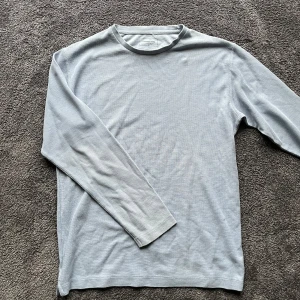 Ljusblå långärmad tröja från Dressmann - Riktigt schysst ljusblå tröja från dressman. Stilren design och ser snyggt ut till blåa jeans. Storlek M